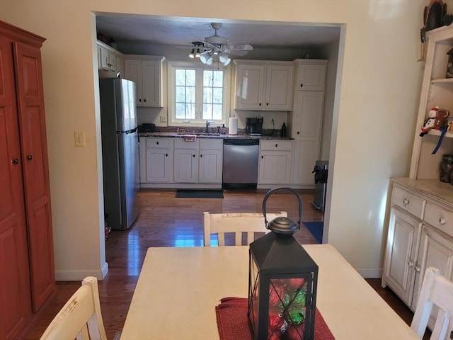 kitchen featuring sink, ceiling fan, appliances with stainless steel finishes, dark hardwood / wood-style floors, and white cabinets