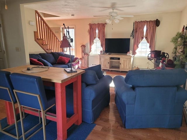 living room featuring dark wood-type flooring and ceiling fan