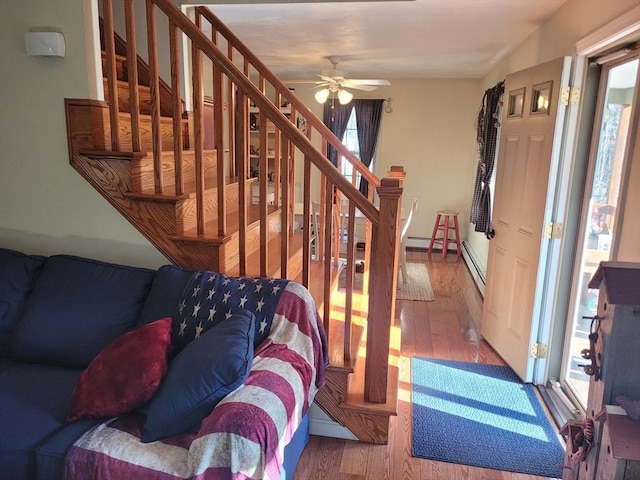 interior space with wood-type flooring, ceiling fan, and baseboard heating