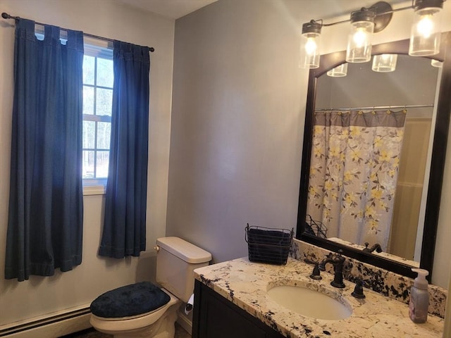 bathroom featuring a healthy amount of sunlight, toilet, vanity, and a baseboard heating unit