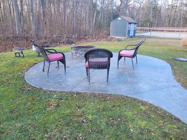 view of patio / terrace with a storage shed and an outdoor fire pit