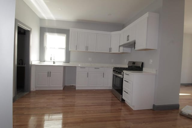 kitchen with stainless steel range with gas cooktop, white cabinets, and light wood-style flooring