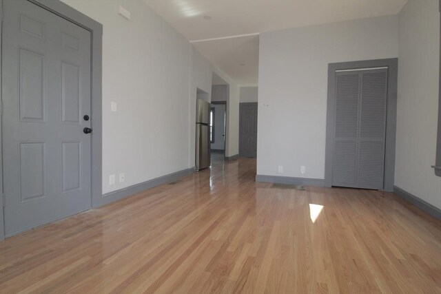 unfurnished living room with light wood-style floors and baseboards