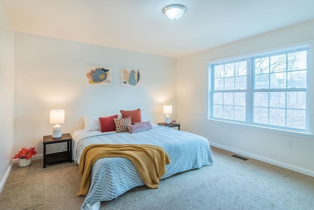 bedroom with visible vents, carpet floors, multiple windows, and baseboards