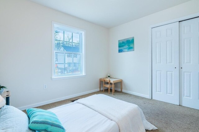 carpeted bedroom with baseboards and a closet