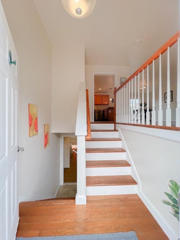 staircase with baseboards and wood finished floors