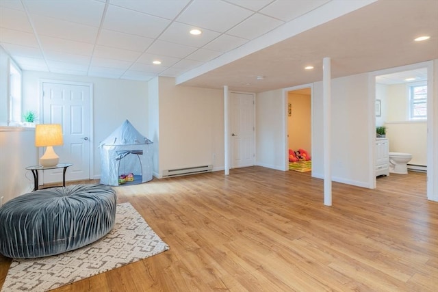 living area featuring a baseboard heating unit, recessed lighting, light wood-style floors, and baseboards