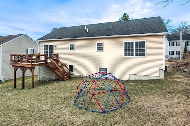 back of property featuring stairway, a yard, a deck, and a shingled roof