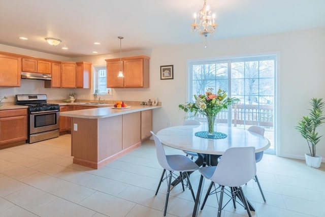 kitchen with under cabinet range hood, light countertops, recessed lighting, a peninsula, and stainless steel gas stove