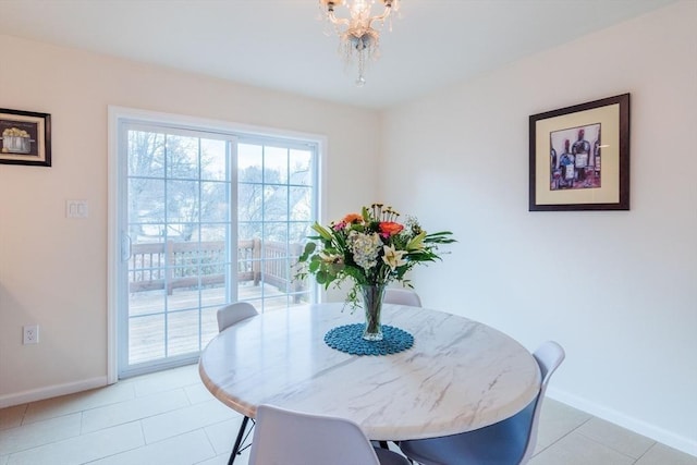 dining space featuring light tile patterned floors, an inviting chandelier, and baseboards