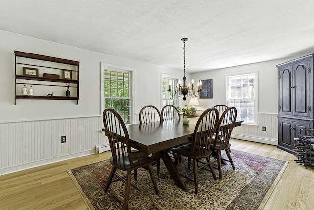 26 E St, Hopkinton, MA 01748 - dining space with wainscoting, healthy amount of natural light, light wood finished floors, a chandelier, and a baseboard radiator