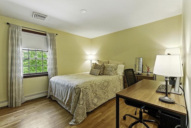 26 E St, Hopkinton, MA 01748 - bedroom with wood finished floors, a baseboard radiator, and an office area
