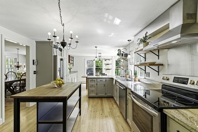 26 E St, Hopkinton, MA 01748 - kitchen with stainless steel appliances, a chandelier, wall chimney exhaust hood, open shelves, and gray cabinets