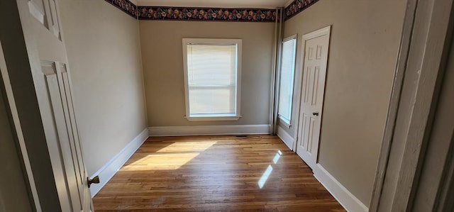 unfurnished room with wood finished floors and baseboards