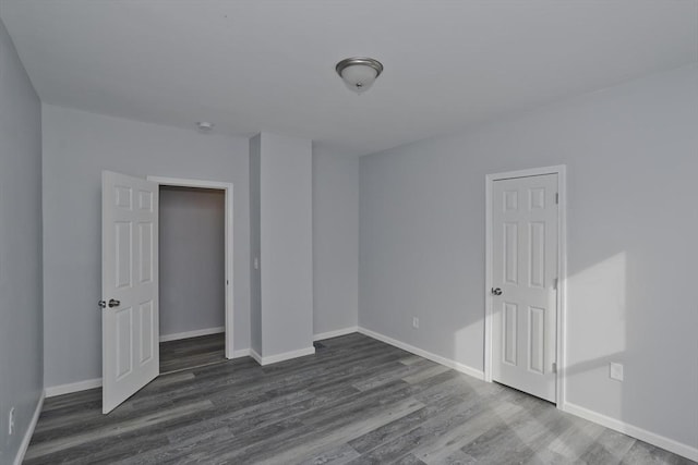 unfurnished bedroom with dark wood-type flooring