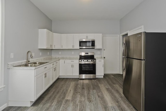 kitchen with white cabinetry, stainless steel appliances, dark hardwood / wood-style floors, and sink