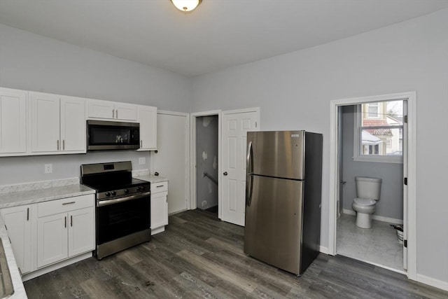 kitchen featuring white cabinetry, appliances with stainless steel finishes, and dark hardwood / wood-style flooring