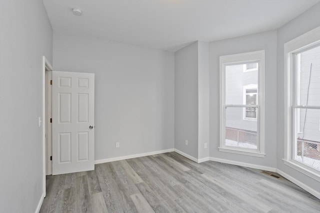 spare room with light hardwood / wood-style flooring and a healthy amount of sunlight