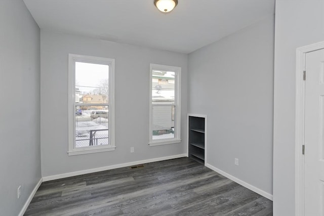 unfurnished room with dark hardwood / wood-style flooring