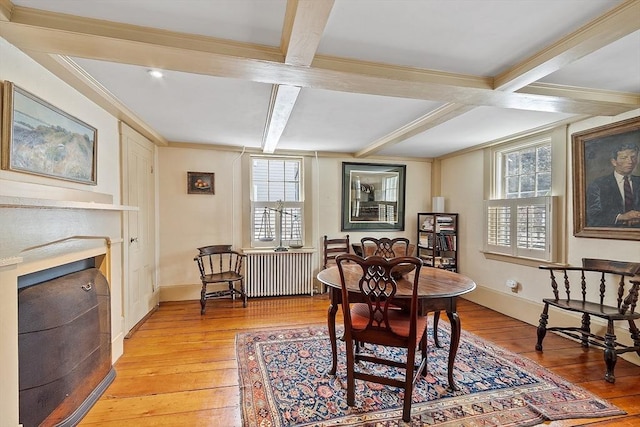 dining room featuring radiator, beam ceiling, crown molding, coffered ceiling, and light wood-type flooring