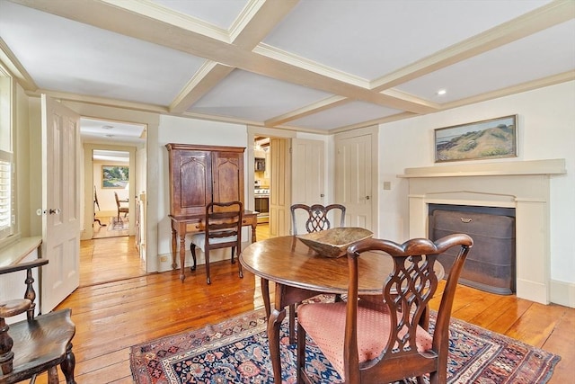 dining area with coffered ceiling, light hardwood / wood-style flooring, ornamental molding, and beam ceiling