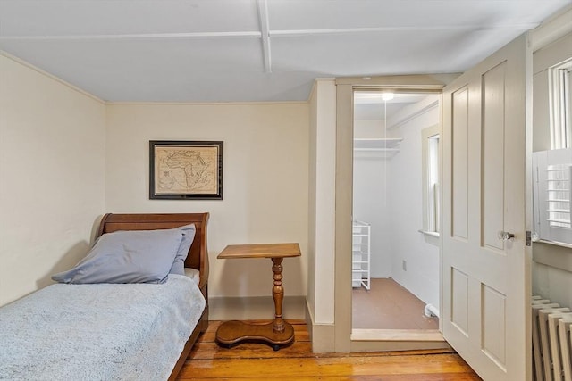 bedroom with hardwood / wood-style floors and radiator