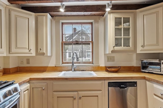 kitchen featuring appliances with stainless steel finishes, sink, and cream cabinets