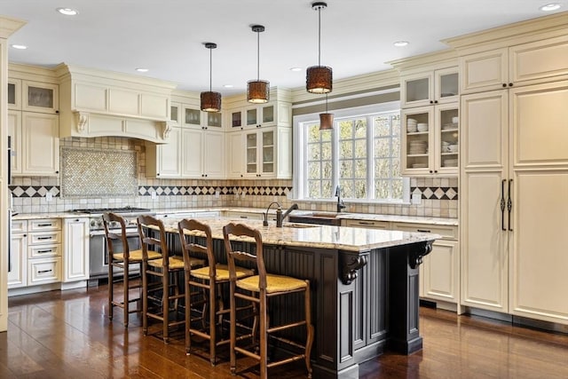 33 Old Concord Rd, Lincoln, MA 01773 - kitchen featuring decorative backsplash, high end stainless steel range, cream cabinetry, and a center island with sink
