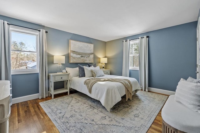 bedroom with multiple windows and dark hardwood / wood-style floors