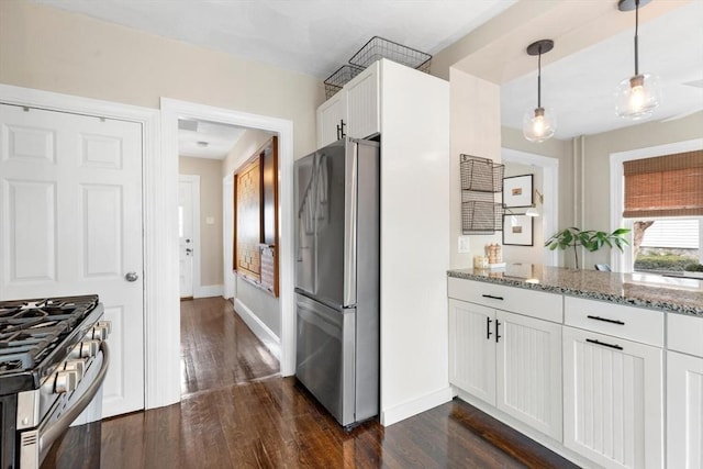 kitchen featuring stainless steel appliances, dark wood-style flooring, white cabinets, and light stone counters