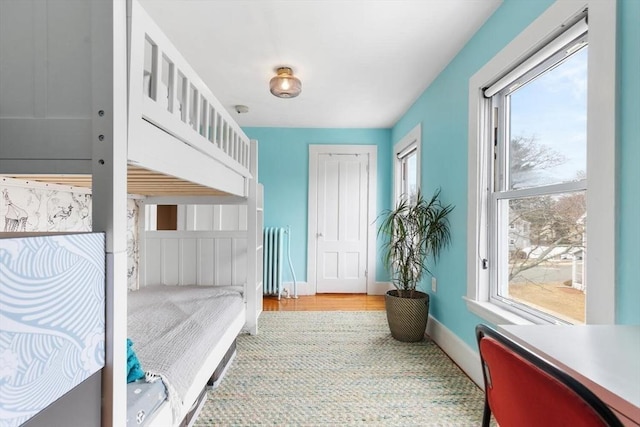 bedroom featuring radiator heating unit, baseboards, and a closet