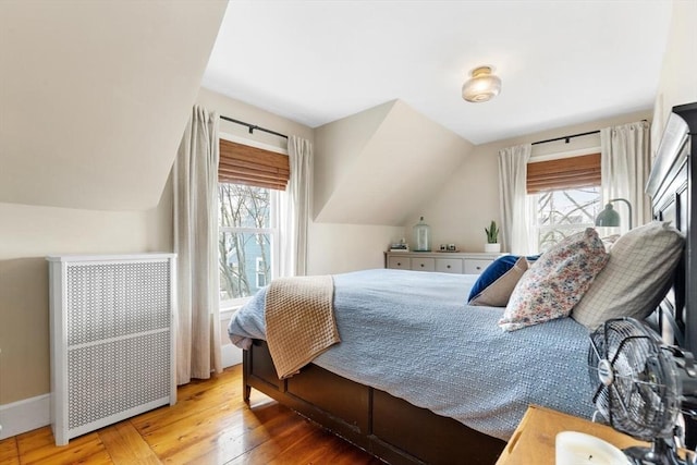 bedroom with wood-type flooring and vaulted ceiling