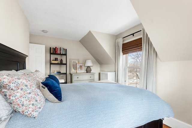 bedroom with vaulted ceiling and baseboards