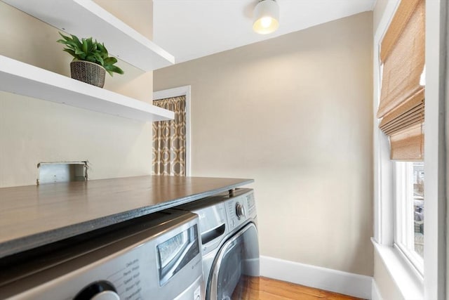 washroom with laundry area, light wood-style flooring, baseboards, and independent washer and dryer