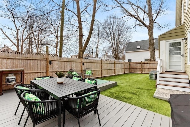 deck featuring a yard, outdoor dining area, and a fenced backyard