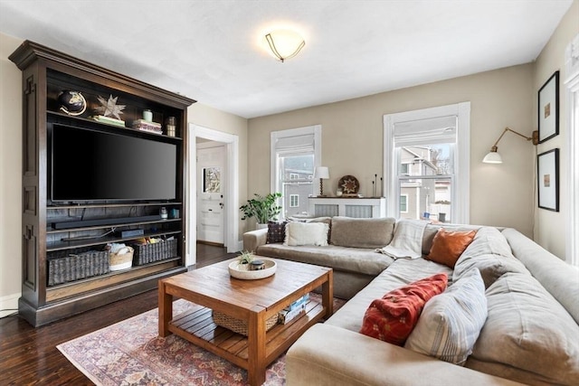 living room with baseboards, dark wood-style flooring, and a wealth of natural light