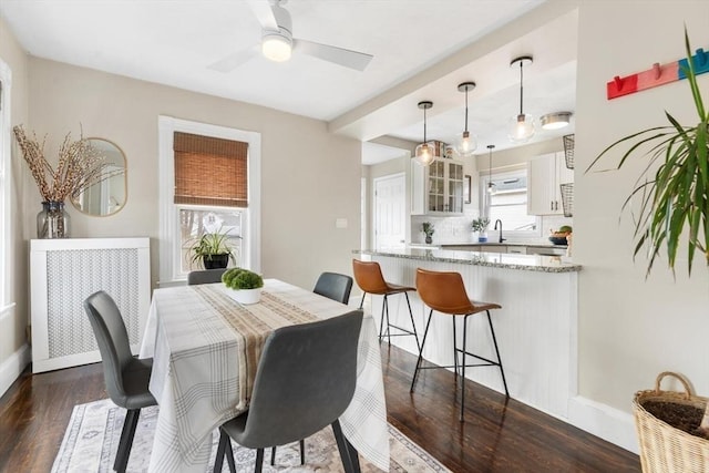 dining room with ceiling fan, dark wood finished floors, and baseboards