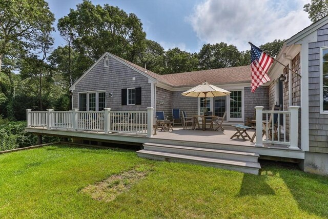 rear view of house with a wooden deck and a yard