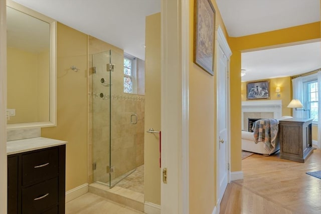 8 Colbourne Cres Unit 1, Brookline, MA 02445 - ensuite bathroom featuring a stall shower, a fireplace, baseboards, and wood finished floors