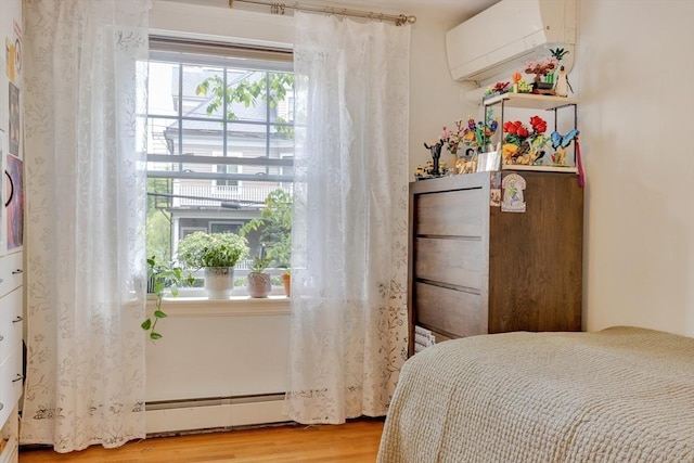 8 Colbourne Cres Unit 1, Brookline, MA 02445 - bedroom featuring light wood finished floors, a wall unit AC, and a baseboard radiator