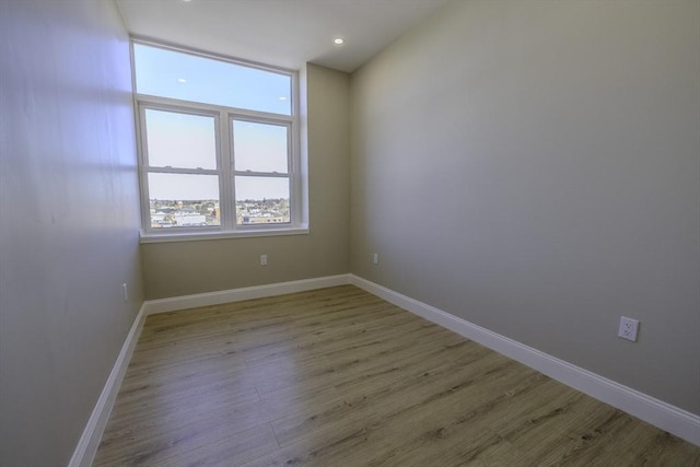 unfurnished room with baseboards and wood finished floors