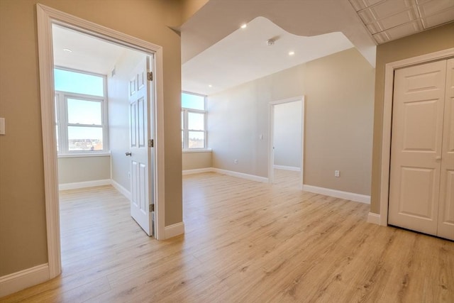 empty room featuring recessed lighting, light wood-type flooring, and baseboards