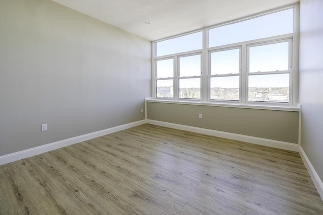 unfurnished room with light wood finished floors and baseboards