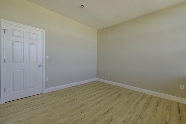 unfurnished room with light wood-style flooring and baseboards