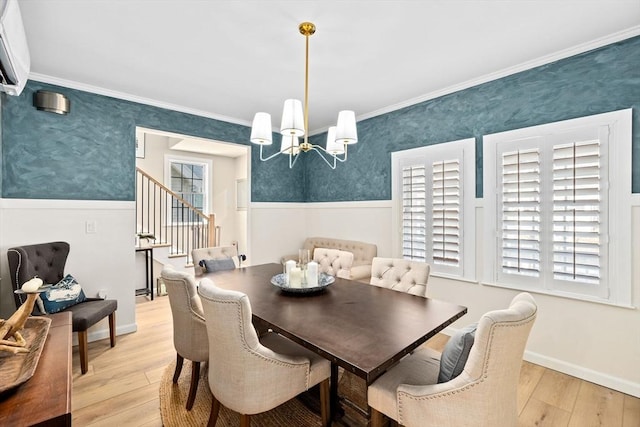 dining space with plenty of natural light, ornamental molding, light hardwood / wood-style floors, and a notable chandelier