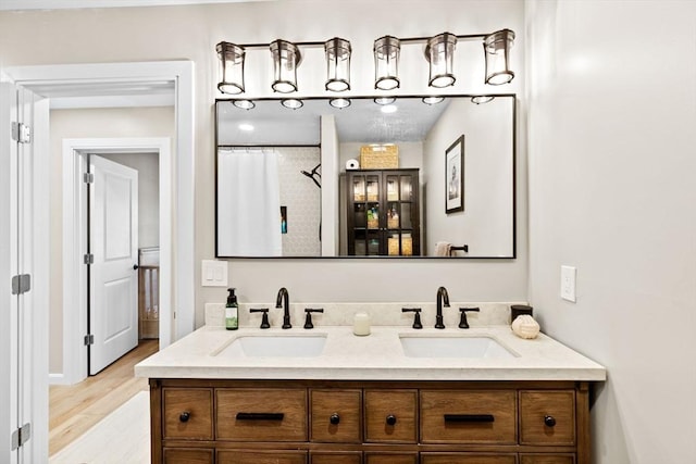 bathroom with walk in shower, vanity, and wood-type flooring