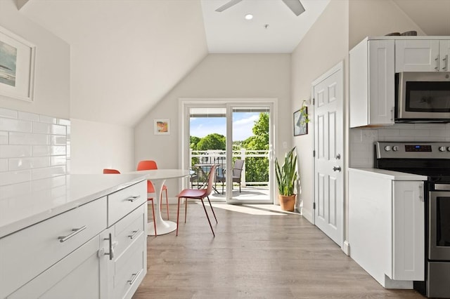 870 S S Unit 3, Boston, MA 02131 - kitchen featuring appliances with stainless steel finishes, lofted ceiling, tasteful backsplash, light wood-style floors, and white cabinetry