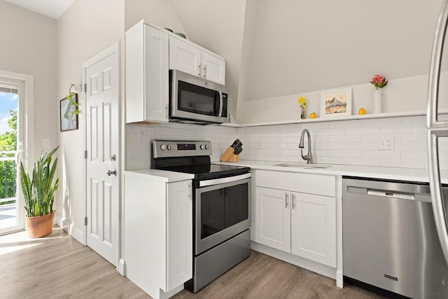 870 S S Unit 3, Boston, MA 02131 - kitchen with appliances with stainless steel finishes, a sink, open shelves, light countertops, and light wood finished floors