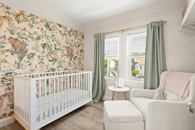 870 S S Unit 3, Boston, MA 02131 - bedroom with wallpapered walls, wood finished floors, a crib, and baseboards