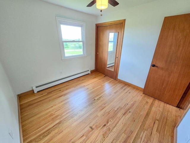 264 Dresser Hill Rd, Dudley, MA 01571 - unfurnished bedroom with a baseboard heating unit, light wood-style flooring, baseboards, and a ceiling fan